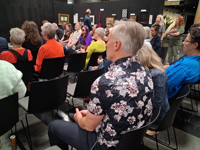 People seated around a stage for the  auction